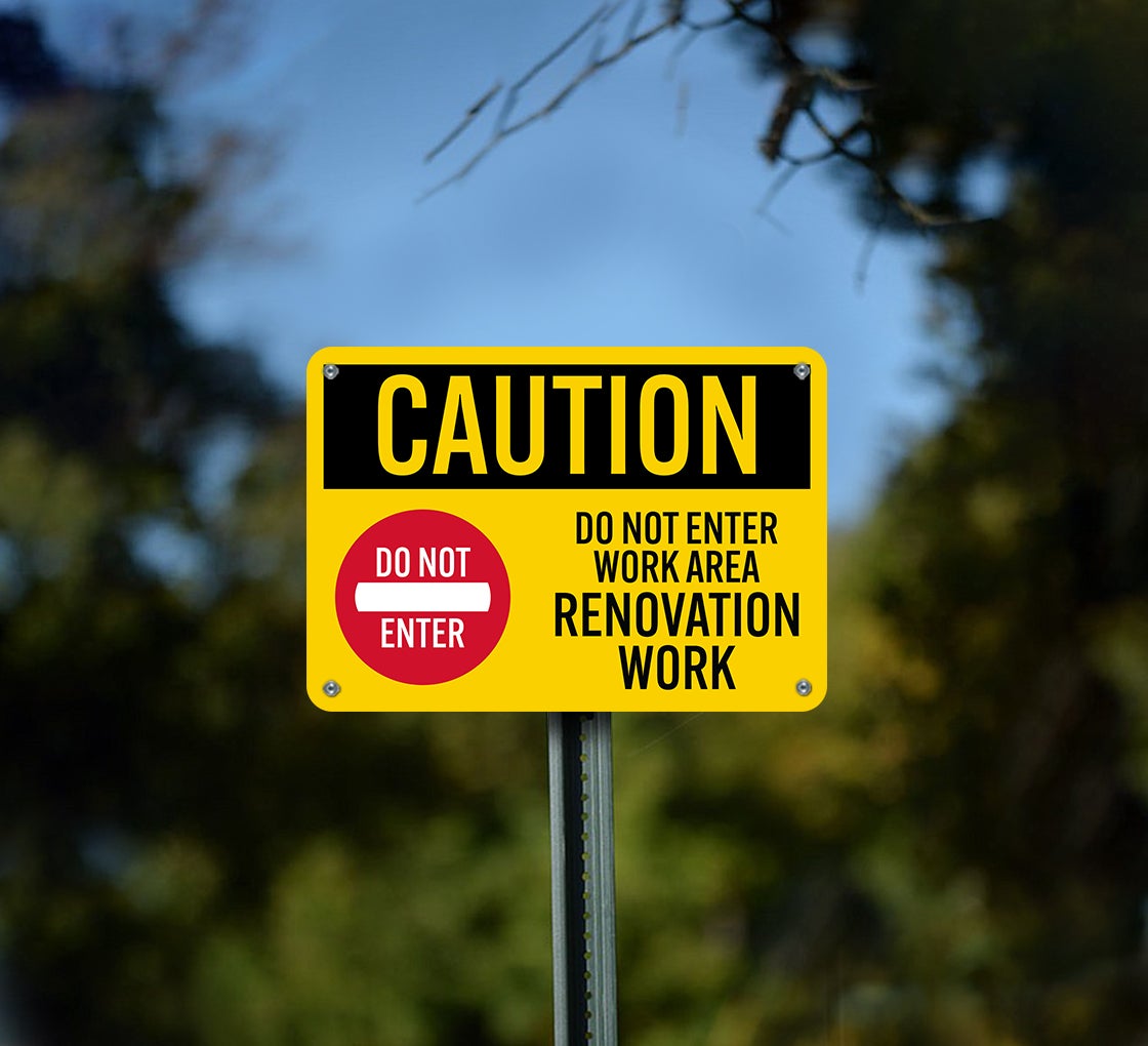 Yellow renovation caution sign mounted outdoors with do not enter wording
